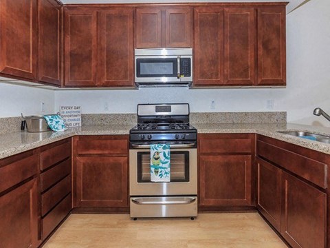 a kitchen with wooden cabinets and a stainless steel stove