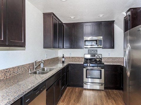 a kitchen with granite counter tops and stainless steel appliances