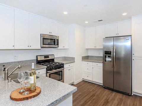 a kitchen with white cabinets and a stainless steel refrigerator