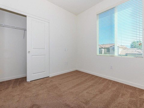 an empty bedroom with a closet and a window