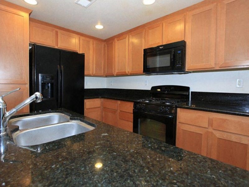 a kitchen with black appliances and granite counter tops