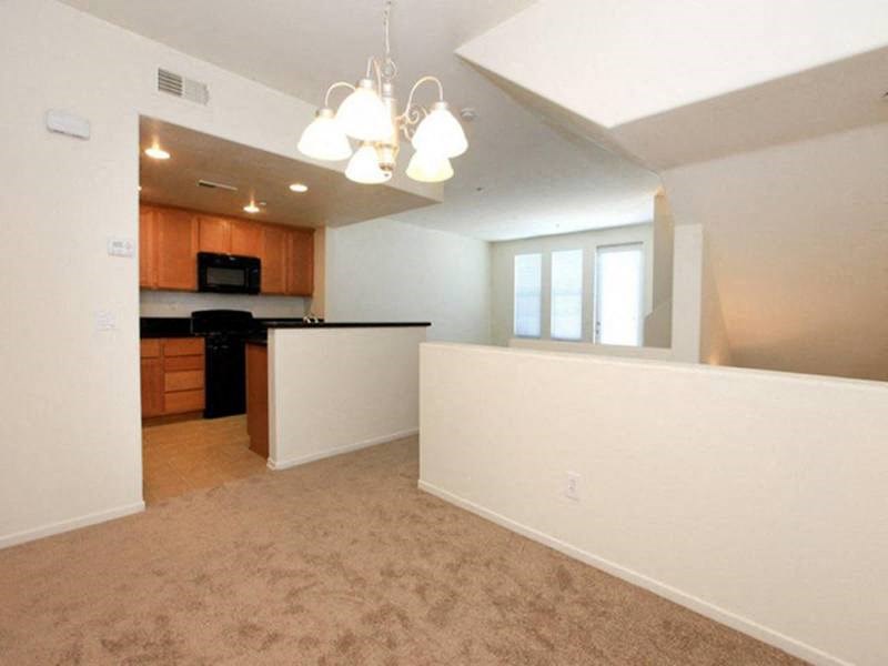 an empty kitchen and living room with a white wall