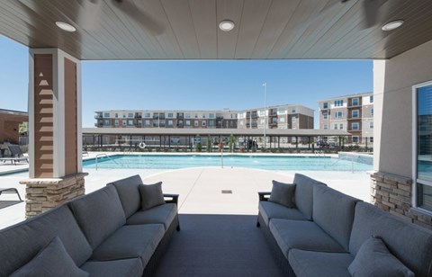 A large outdoor seating area with a pool and apartment buildings in the background at Woodstone at Metro North Crossing Apartments, Missouri