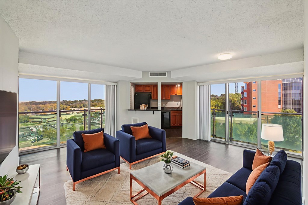 A living room with blue chairs and a glass table.