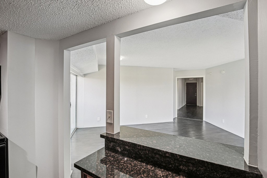 A hallway with a marble counter top and a mirror on the wall.