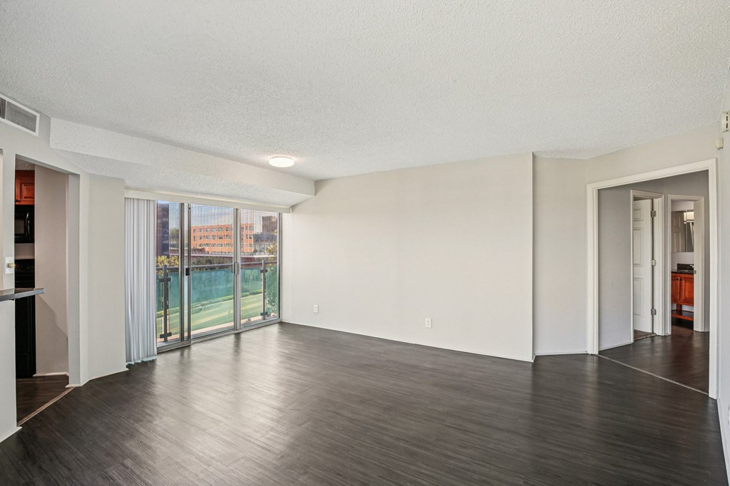 A large empty room with wooden floors and white walls.