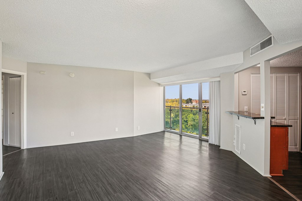 A large empty room with wooden floors and white walls.