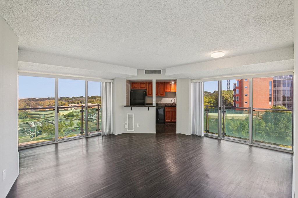A spacious living room with a flat screen TV and sliding glass doors.