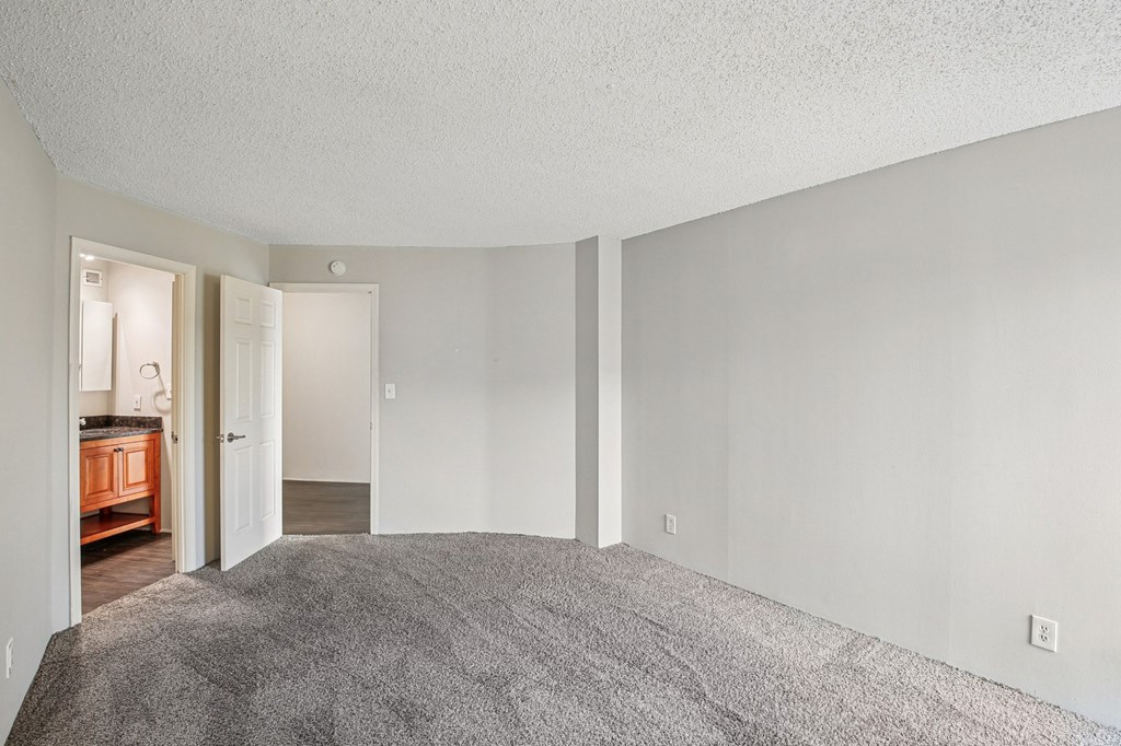 A room with a grey carpet and white walls.