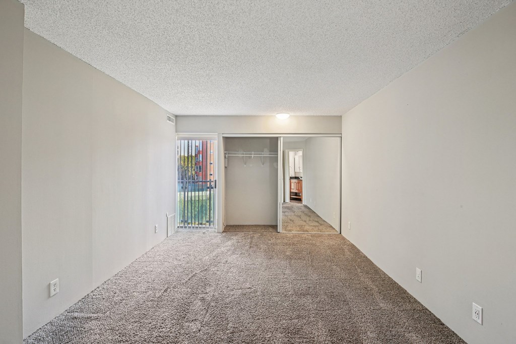 A long, empty hallway with a carpeted floor and white walls.