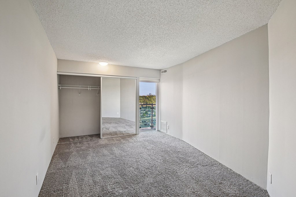 A room with a grey carpet and white walls.