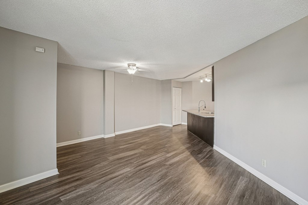A room with wooden flooring and white walls.