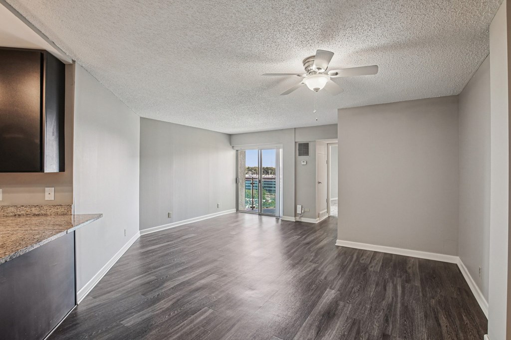 A room with a ceiling fan and wooden flooring.