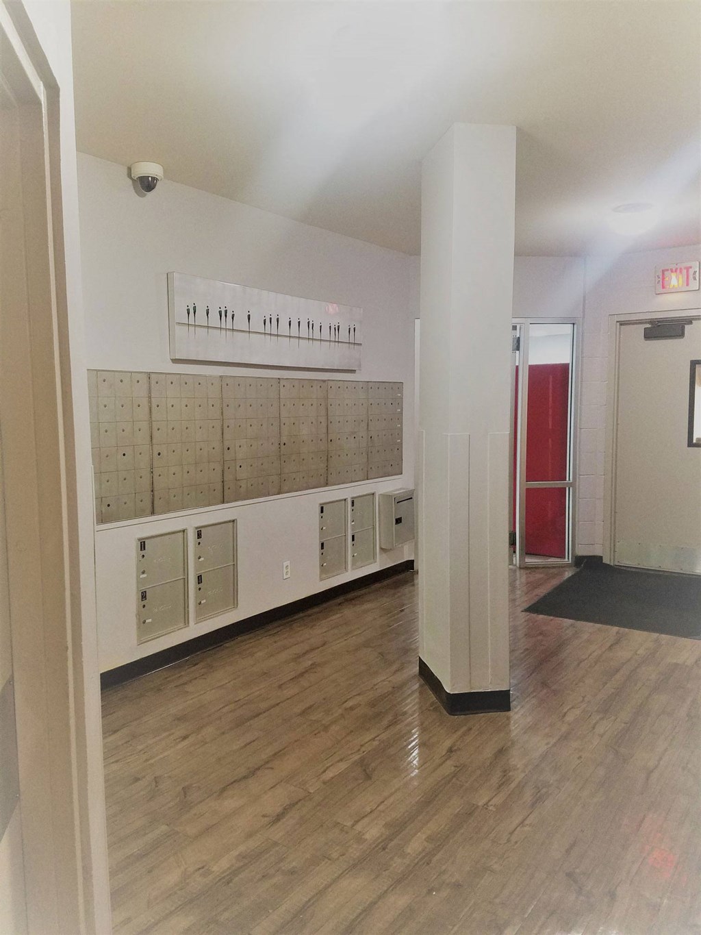 a hallway with white walls and wooden floors and lockers at Vista Condominiums, Kansas City, Kansas