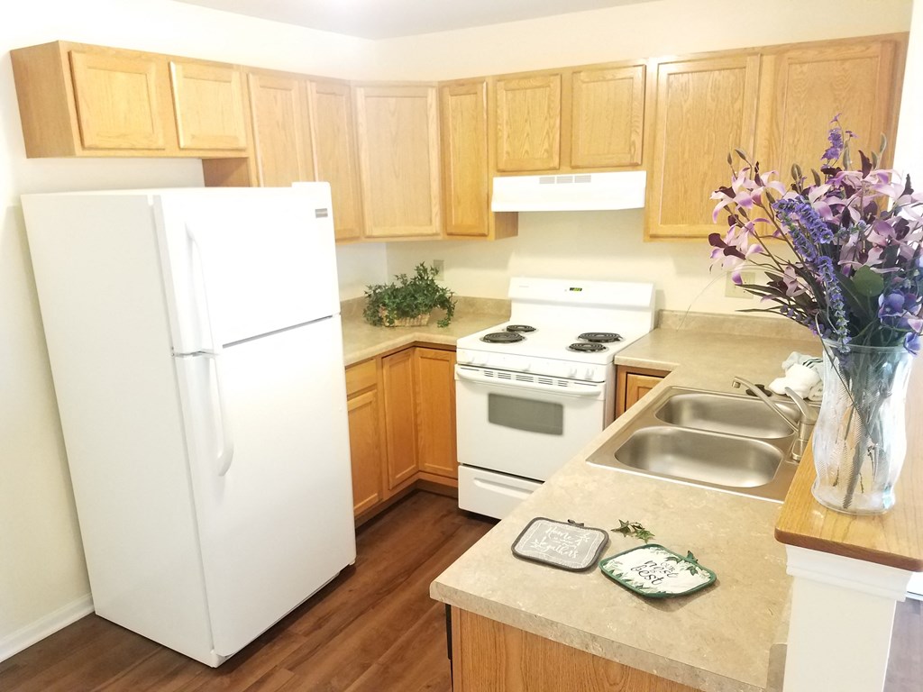 a kitchen with white appliances and wooden cabinets