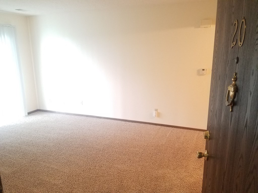 an empty room with a door and a white wall