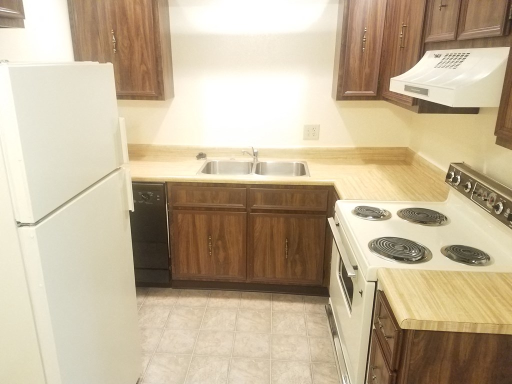an empty kitchen with a stove refrigerator and sink