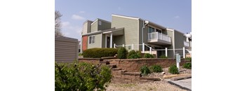 A building with a green and grey exterior and a balcony.