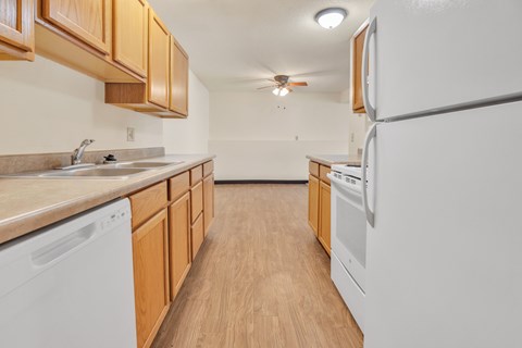 A kitchen with wooden cabinets and white appliances.