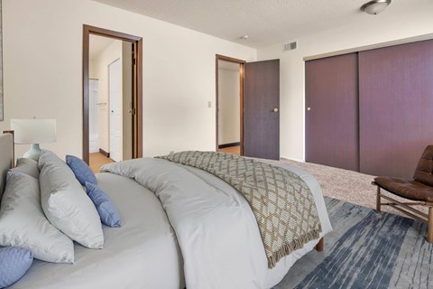 A bedroom with a large bed and a chair. at Winding Hills Apartments, Davenport  52807