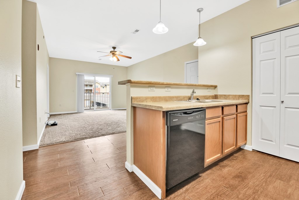 A kitchen with a wooden counter and a black dishwasher.
