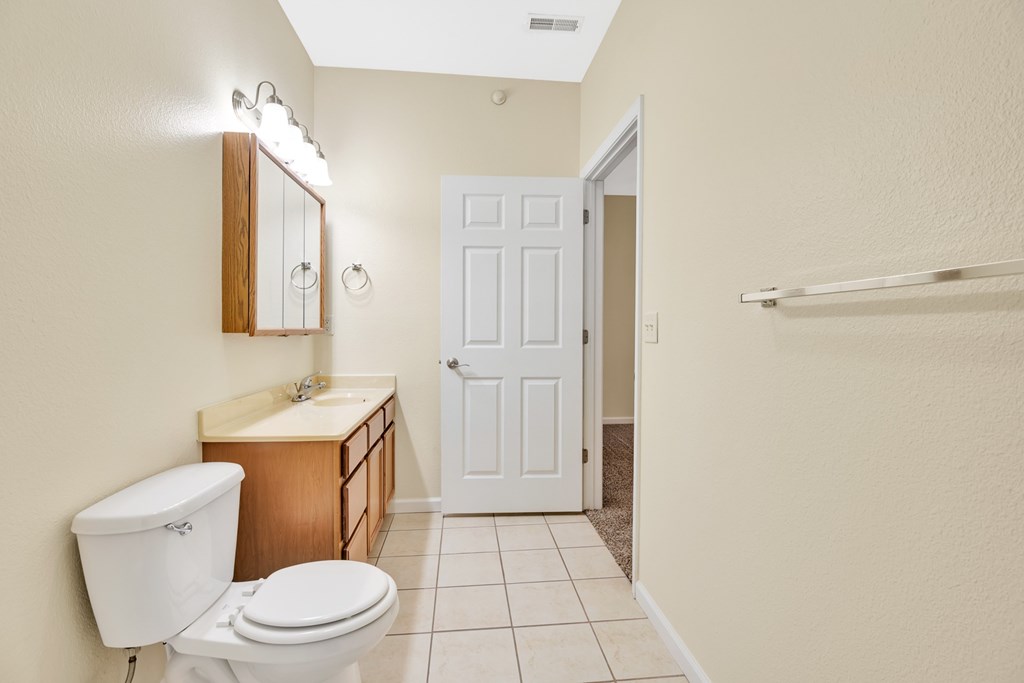 A white toilet sits next to a sink in a bathroom.