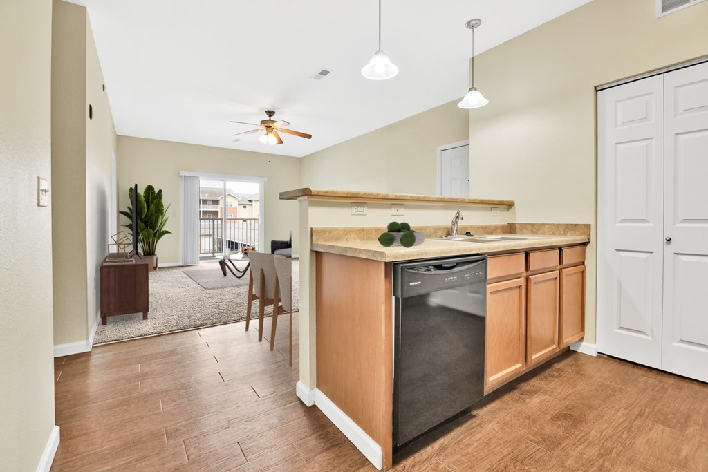 A kitchen with a wooden counter and a black dishwasher.
