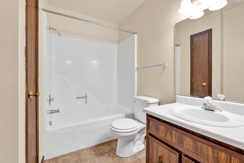 A white toilet sits next to a white sink in a bathroom.