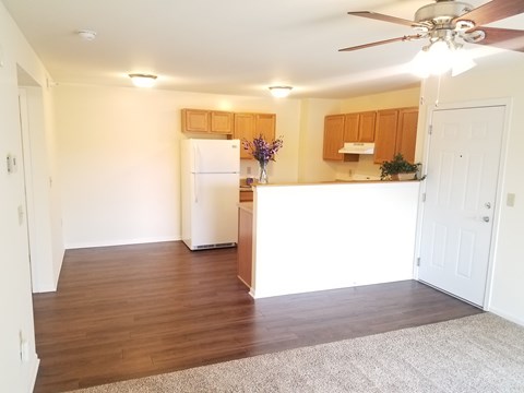 A kitchen with a white refrigerator and wooden cabinets.