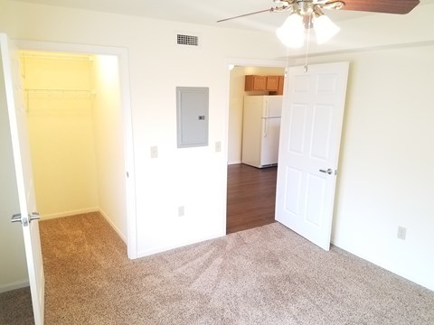 A room with a ceiling fan and a door.