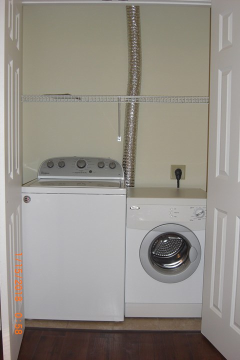A white washing machine and dryer in a small laundry room.