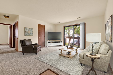 A living room with a brown leather chair and a grey couch.