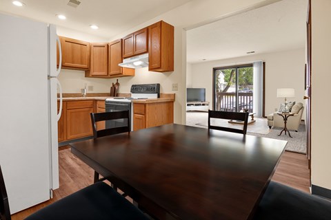 A kitchen with a table and chairs in the foreground.