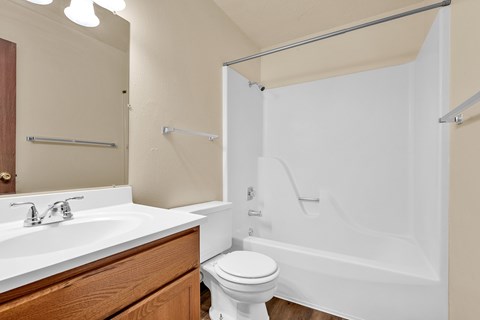 A white toilet sits next to a white sink in a bathroom.