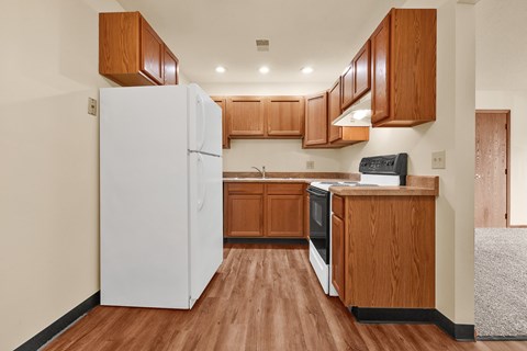 A kitchen with wooden cabinets and a white refrigerator.