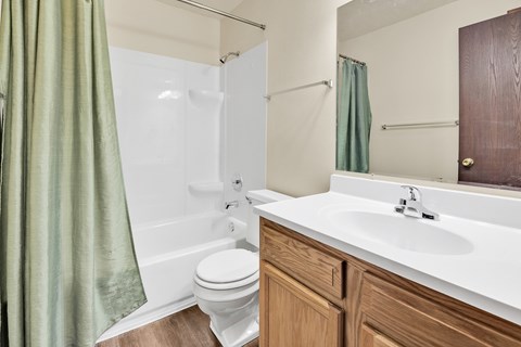 A white toilet sits next to a white sink in a bathroom.