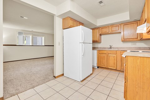 A kitchen with a white fridge and wooden cabinets.