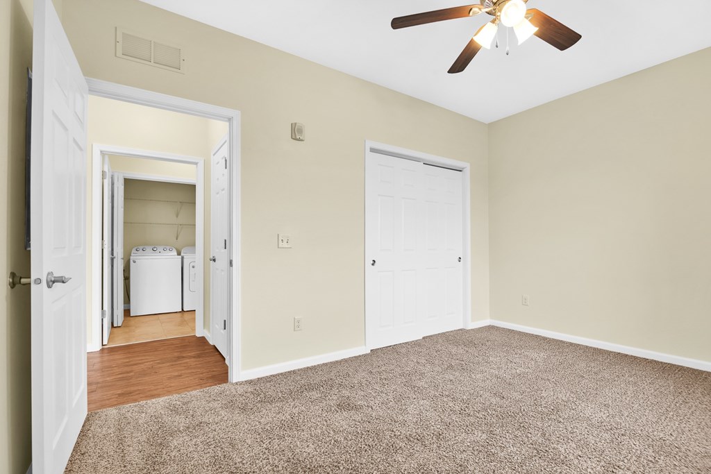 A room with a ceiling fan and a carpeted floor.