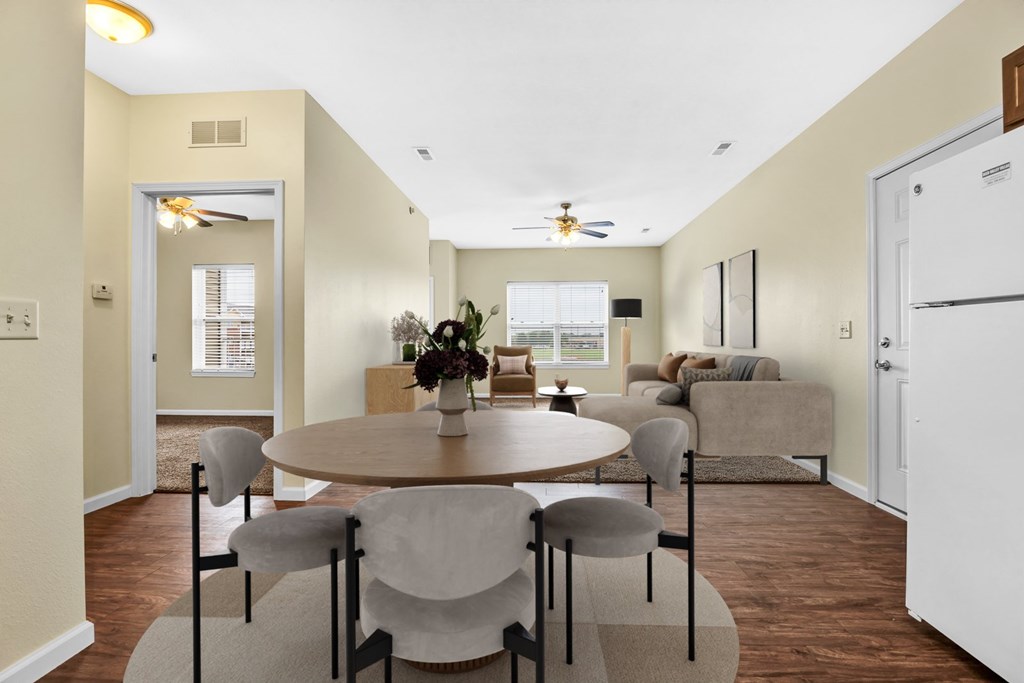 A dining room with a round table and grey chairs.
