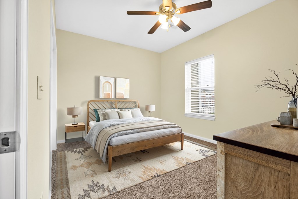 A bedroom with a bed, nightstand, and a ceiling fan.