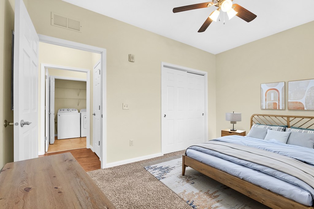 A bedroom with a bed, a ceiling fan, and a rug.