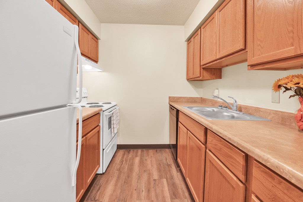 A kitchen with wooden cabinets and a white refrigerator.