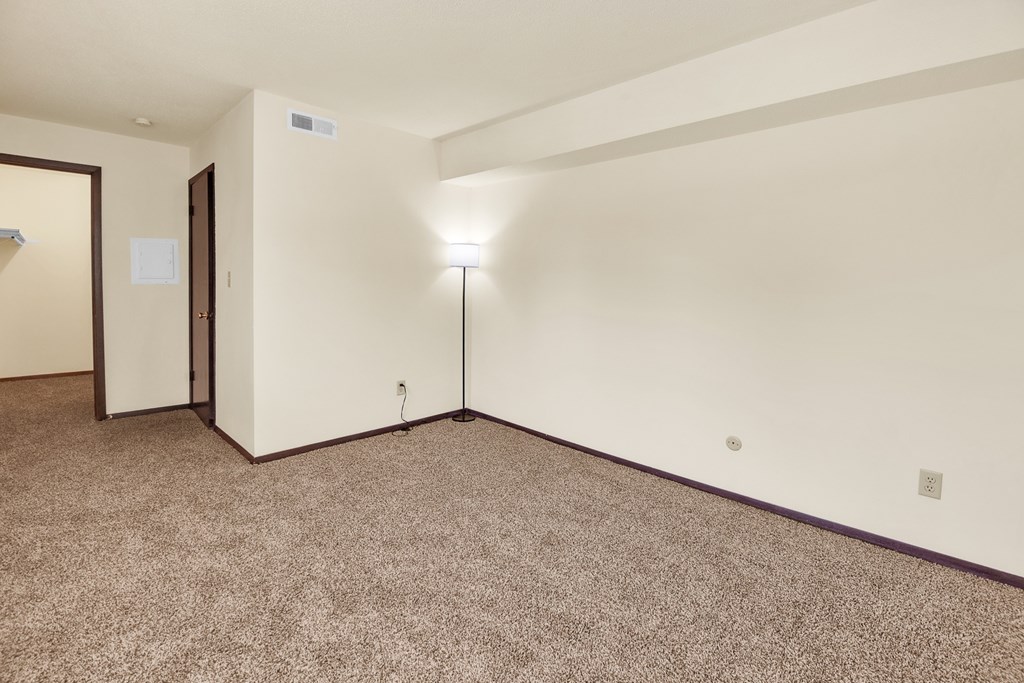 A room with a carpeted floor and a single light on.