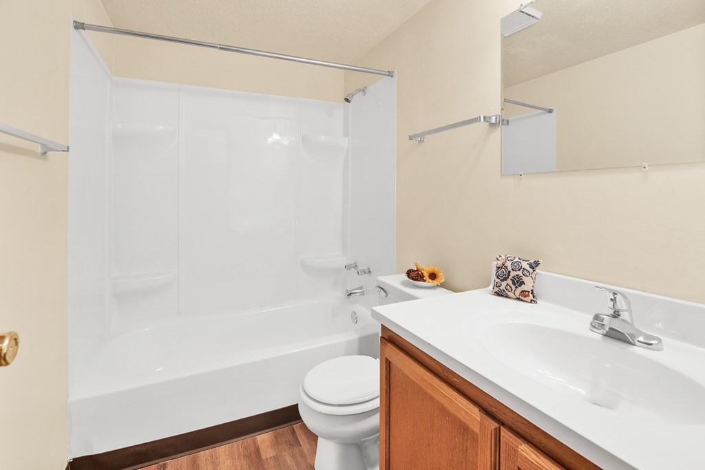 A white toilet sits next to a white sink in a bathroom.