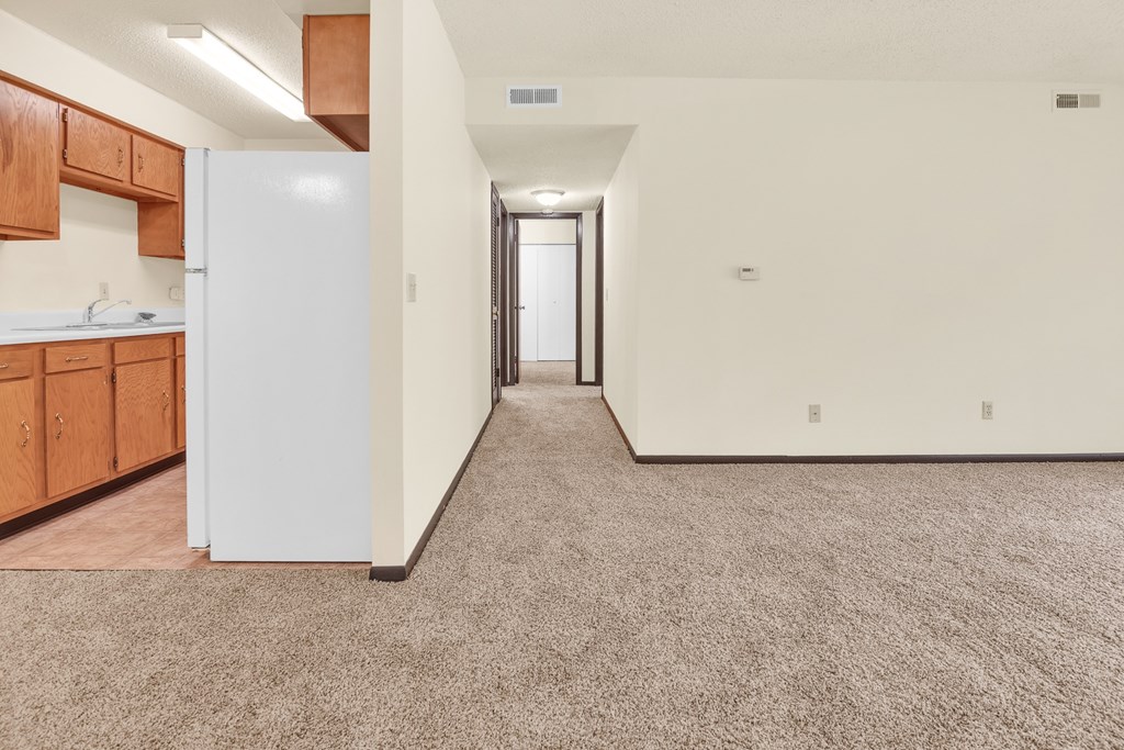 A long hallway with a white door at the end.