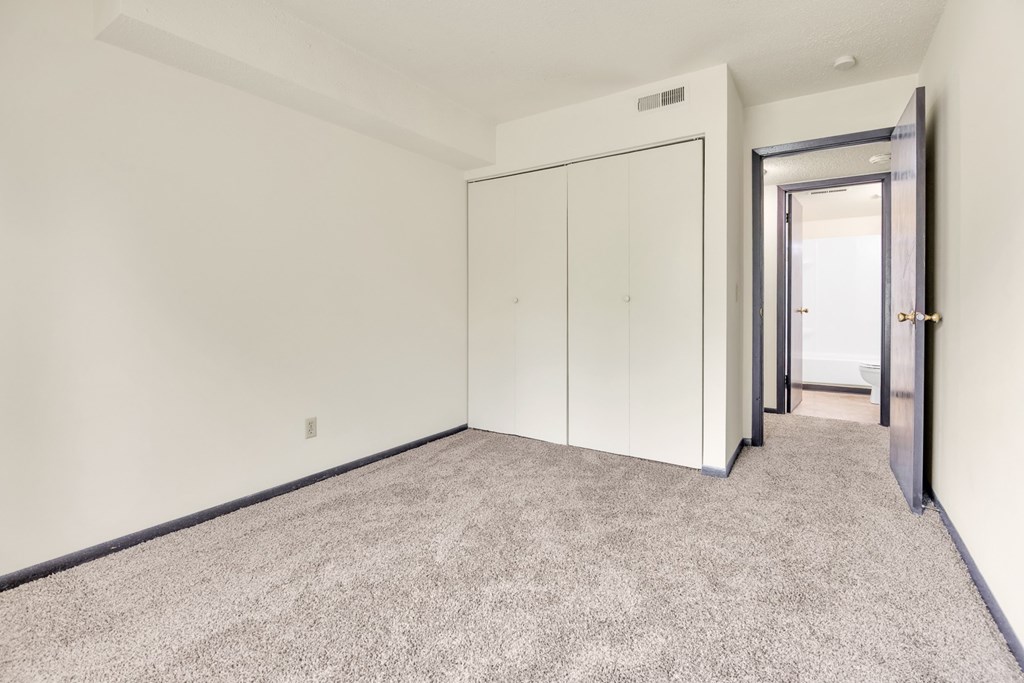 A room with a carpeted floor and a white wall.