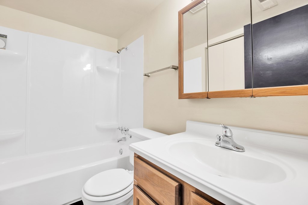 A white toilet sits next to a white sink in a bathroom.