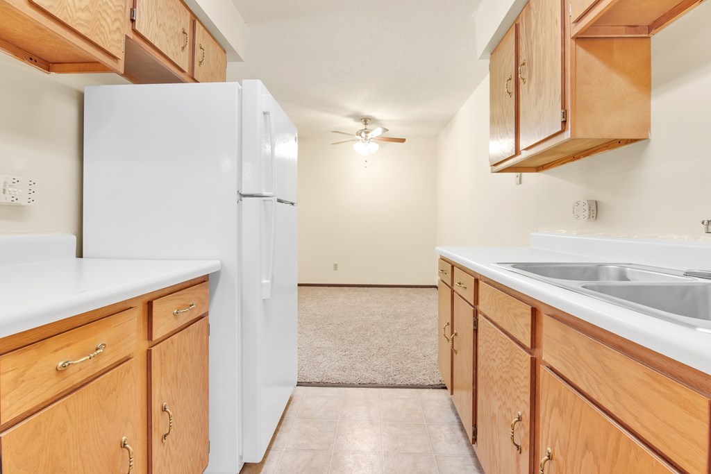 A kitchen with wooden cabinets and a white refrigerator.