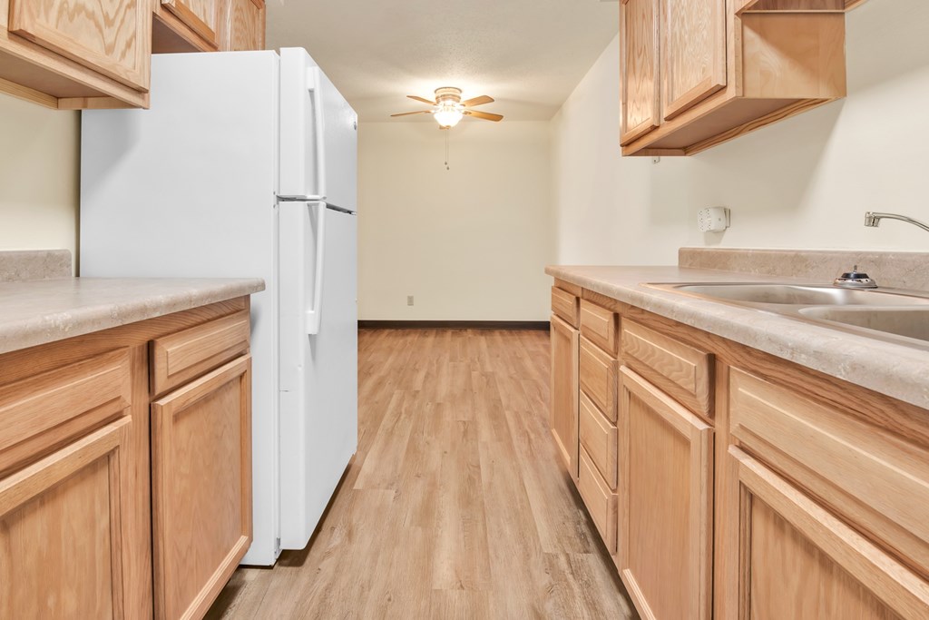 A kitchen with wooden cabinets and a white refrigerator.