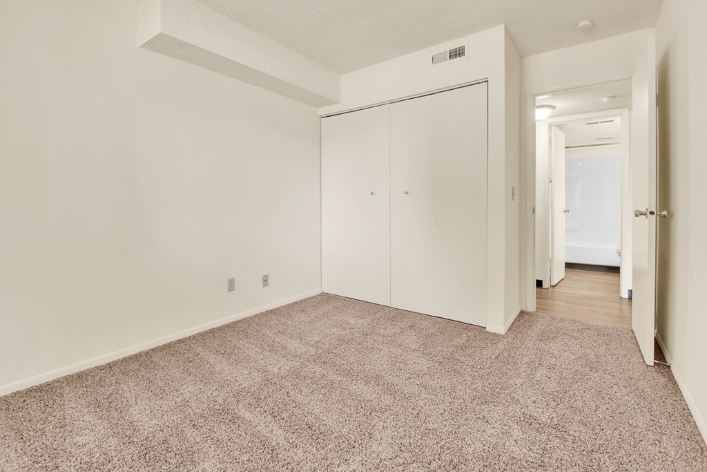 A room with a carpeted floor and a white door.